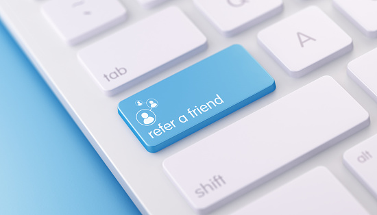 High quality 3d render of a modern keyboard with refer a friend button on a blue background and copy space. The refer a friend keyboard button has a text  and an icon on it. The refer a friend keyboard button is  in focus, Great use for refer a friend and referral concepts.